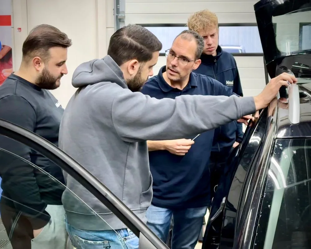 Trainer in gesprek met cursisten over raamfolies tijdens Appcademy Automotive Windowfilm opleiding en training