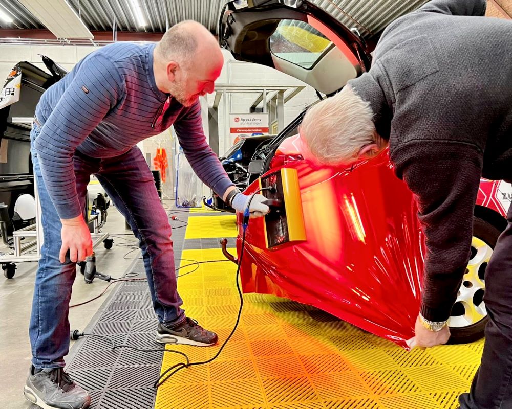 Cursisten wrappen met behulp van infra rood verwarming tijdens de Appcademy carwrap advanced cursus