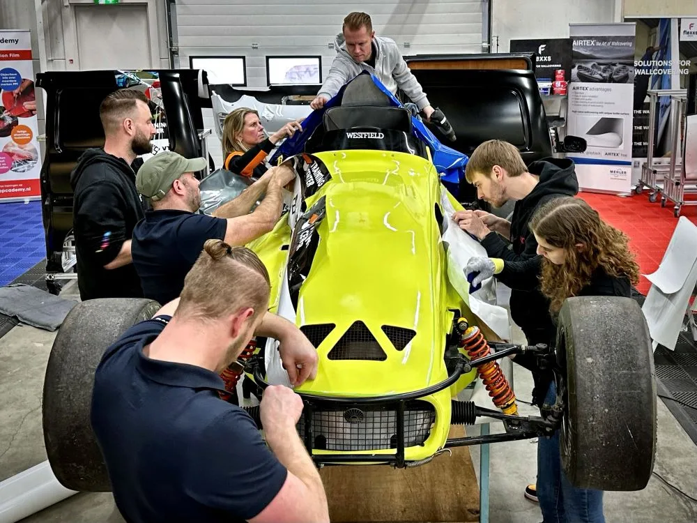 Cursisten wrappen racewagen onder leiding van trainer tijdens Appcademy carwrap advanced cursus opleiding