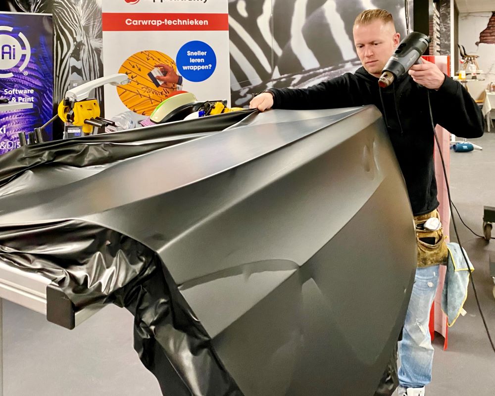 Trainer demonstreert wrappen van achterklep uit 1 deel carwrapfolie tijdens Appcademy carwrap Masterclass cursus