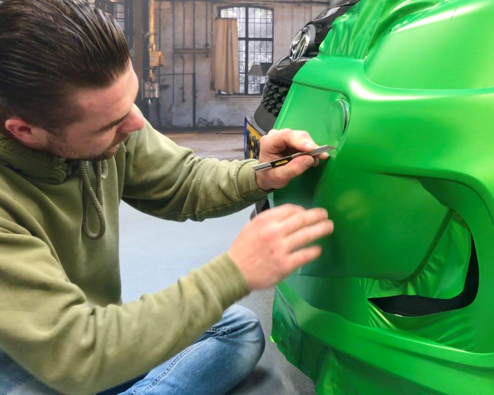 Cursist wrapt bumper tijdens Appcademy carwrapcursus advanced opleiding