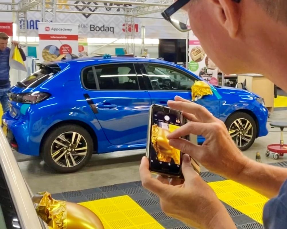 Cursist maakt foto van praktijkoefening carwrap in trainingscentrum Appcademy opleidingen