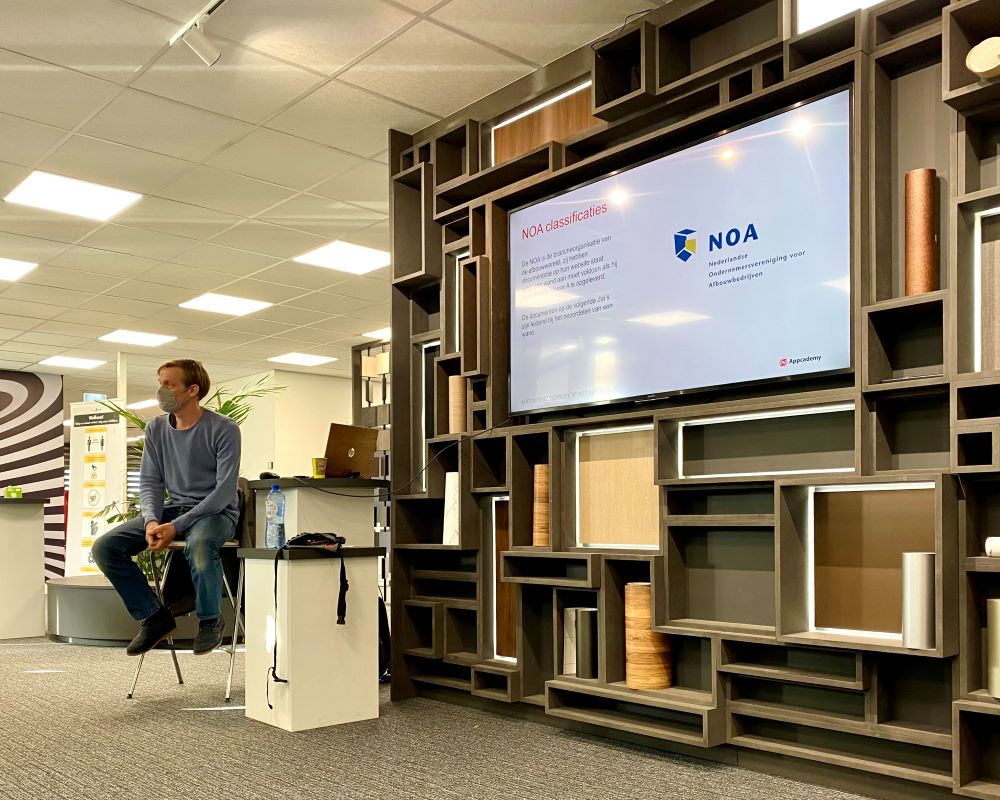 Trainer deelt praktische informatie met cursisten tijdens Appcademy Cursisten wrappen stoelen tijdens de Appcademy cursus opleiding interieurfolie en keukens wrappeninterieurfolie plakken en keukens wrappen