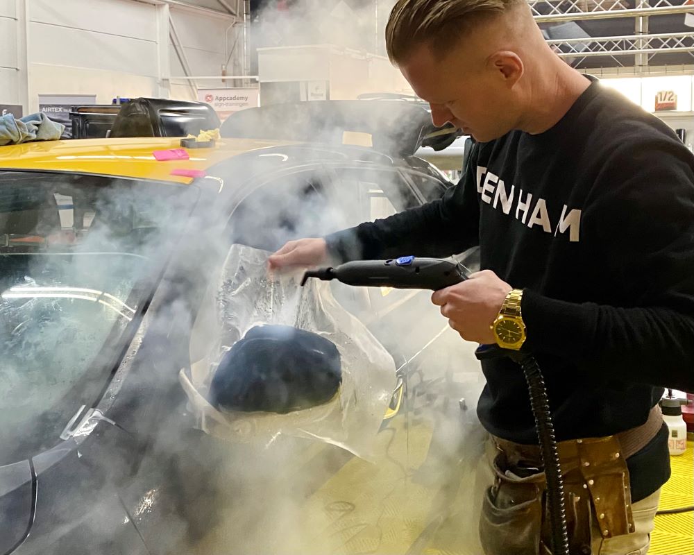 Cursist gebruikt stoom bij aanbrengen PPF op buitenspiegel tijdens Appcademy Paint Protection Film opleiding en training