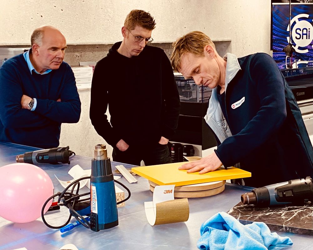 Trainer demonstreert de methode van het wrappen met interieurfolie op keukendeurtjes tijdens Appcademy cursus keukens wrappen