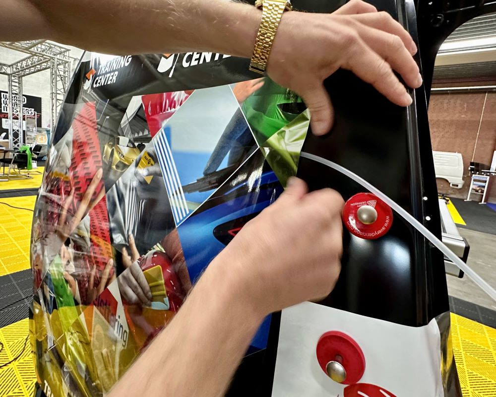 Trainer geeft waardevolle tips aan signmakers die zelfklevende folies en prints willen inföhnen in profileringen in bestelbussen tijdens de Appcademy signmaker advanced cursus en opleiding