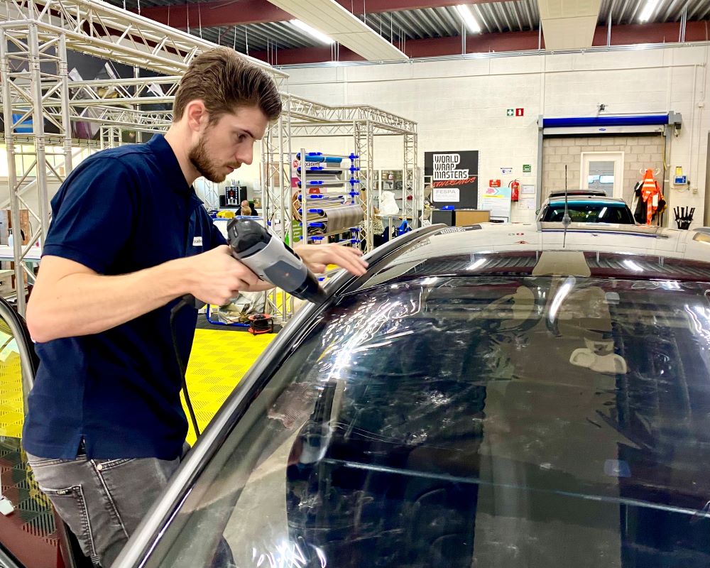 Trainer demonstreert het krimpen van plooien in nog te plakken raamfolie tijdens Appcademy Automotive Windowfilm cursus