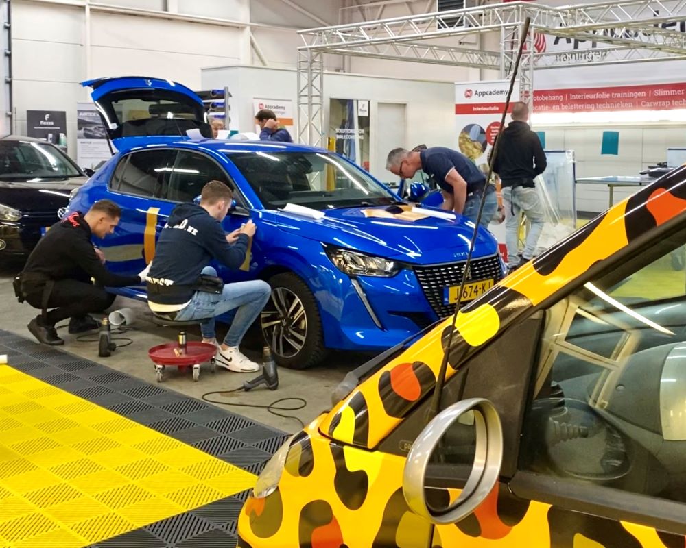 Cursisten leren carwrap afwerken tijdens Appcademy carwrapping training
