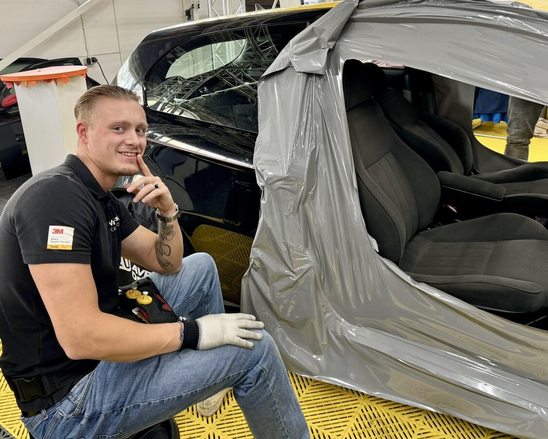 Blije cursist tijdens cursus carwrap masterclass waar binnenzijde auto's worden gewrapped